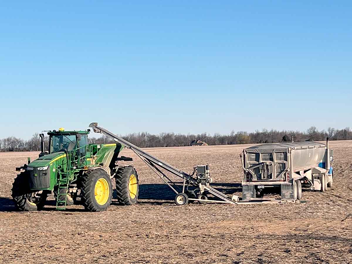 Doyle field loader conveyor in the field loading John Deere tractor spreader